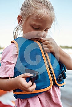 Little girl zipping life west on water coast