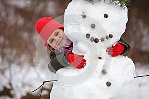 Little girlposing with snowman