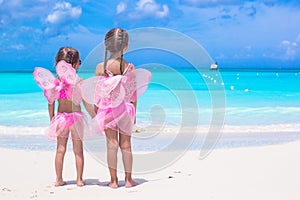 Little girls with butterfly wings on beach summer vacation