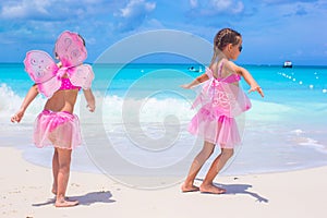 Little girls with butterfly wings have fun beach