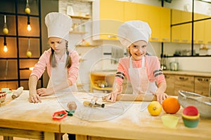 Little girls chefs with rolling pins, funny bakers