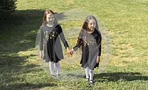 Little Girls, Children Enjoying Summer Time, School Break Walking Public Park At Sunny Day