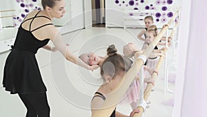 Little girls dance ballet. Children in ballet class. Little ballerinas and teacher. Beautiful view.