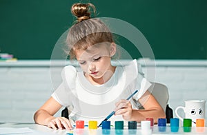 Little girls drawing a colorful pictures with pencil crayons in school classroom. Painting kids. Early childhood