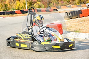 Little girls are driving Go- Kart car in a playground racing track