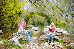 Little girls enjoying the view of deep green waters of Obersee, located near Konigssee, known as Germany`s deepest and cleanest l