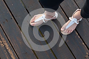 Little girls feet in white sandals photo