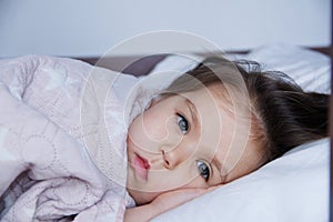 Little girls going to sleep lying on bed. sleep schedule in domestic lifestyle. baby child portrait