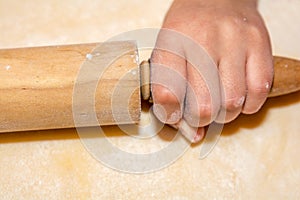 Little girls hand with rolling pin and flour