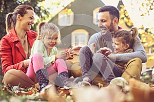 Little girls have fun with parents at backyard.