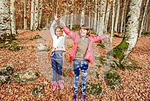 Little girls having fun with laves in autumn in Biogradska Gora