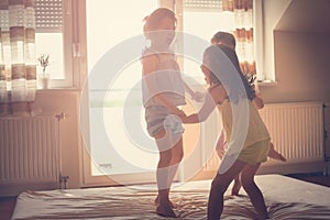 Little girls having fun together in bed.