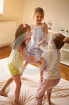 Little girls having fun together in bed. Little girls playing at
