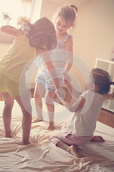 Little girls having fun together in bed.