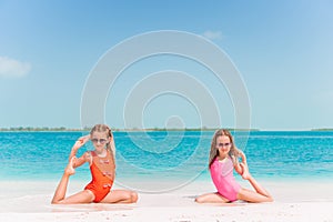 Two little happy girls have a lot of fun at tropical beach playing together