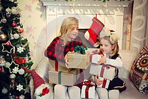 Little girls holding presents by the Christmas tree