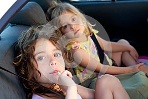 Little girls inside car eating candy stick