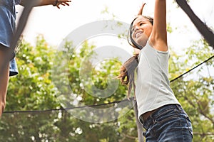 Little girls jumping and playing on a trampoline.