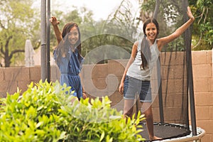 Little girls jumping and playing on a trampoline.