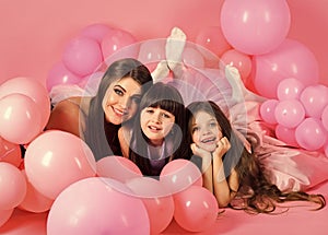 Little girls, mom in pink balloons.