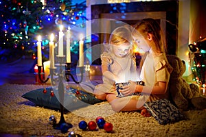 Little girls opening a magical Christmas gift