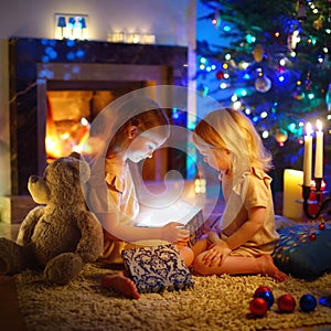 Little girls opening a magical Christmas gift