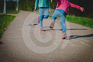 Little girls play hopscotch on playground, kids outdoors