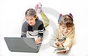 Little girls playing games on the notebook and tablet