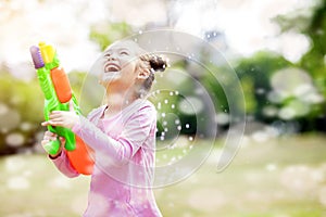 little girls playing water guns in the park