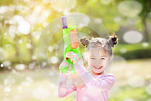 Little girls playing water guns in the park