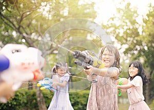 little girls playing with water guns on summer