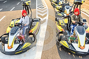 Little girls preparing to drive Go- Kart car in a playground ra