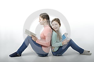 Little girls read books back to back on white