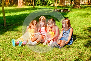 Little girls reading a book in the park