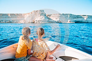 Little girls sailing on boat in clear open sea