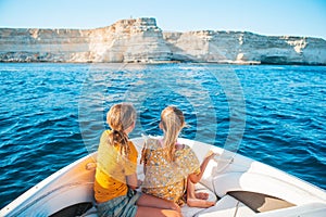 Little girls sailing on boat in clear open sea