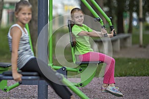 Little girls sitting on exercise equipment