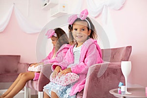 Little girls in spa center on manicure