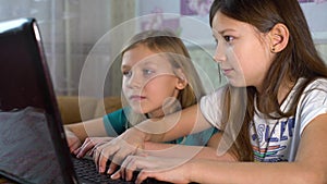 Little girls surfing internet together on laptop