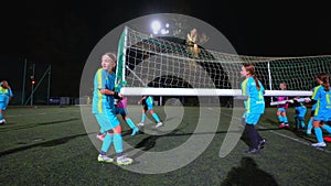 little girls trying to change the position of the football goal-net, full shot