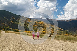 Little Girls Twin Sisters Friends Walking Hand in Hand.