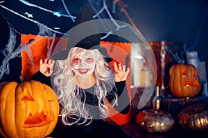 Little girls in witches carnival costume scaring and making faces on background decor Halloween