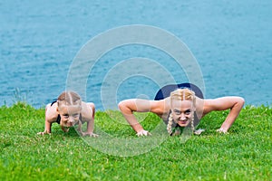 Little girt and woman are doing exercises