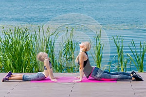 Little girt and woman are doing exercises photo