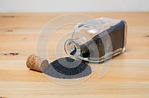 Little glass bottle with black sand or gun powder