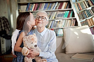 A little granddaughter and her Grandma enjoy emotions while playing and spending time at home together. Family, leisure, together