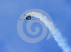 American Champion 8KCAB Decathlon aircraft stunt flying with smoke.