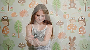 Little gray hamster in children's hands