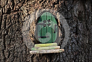 Pequeno verde hada  duende puerta en un árbol maleta 