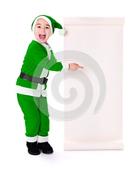 Little green Santa Claus boy pointing at big wish list